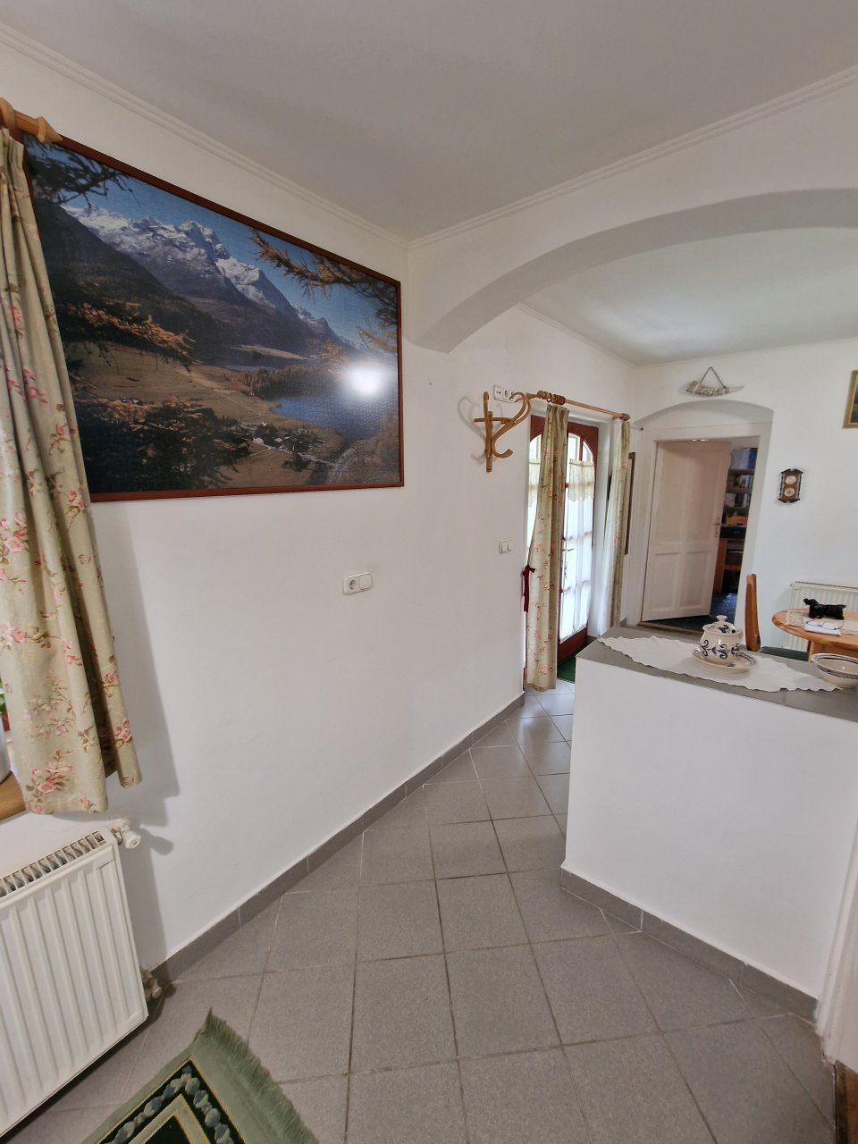 Light-flooded entrance area with elegant room division and harmonious natural stone ambiance