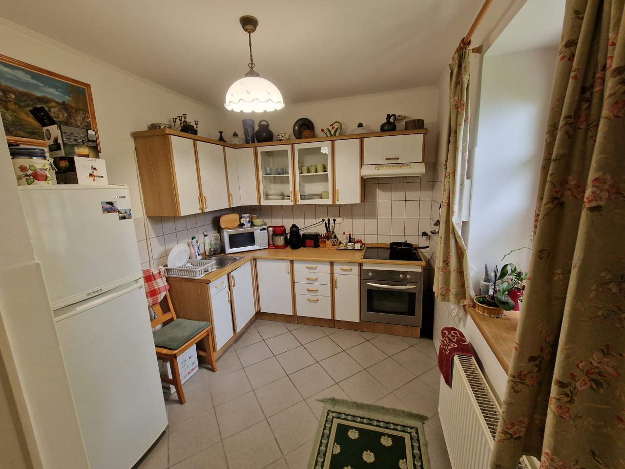 Functional L-shaped kitchen with built-in appliances and generous work surface - Perfect for hobby chefs!