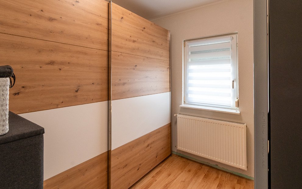 Comfortable bedroom with sliding door built-in wardrobe and skylight window
