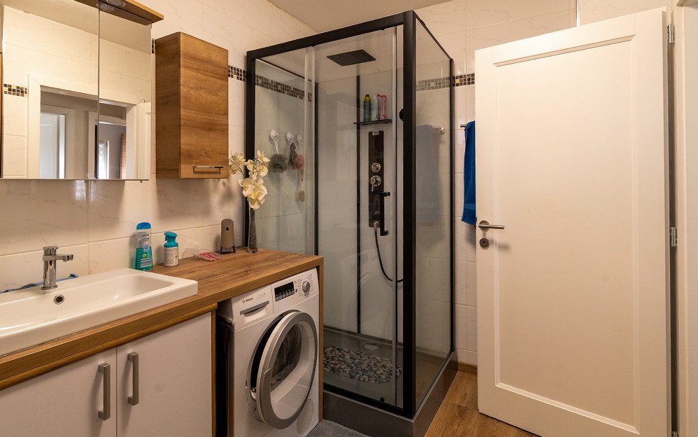 Modern bathroom with walk-in shower and practical laundry integration