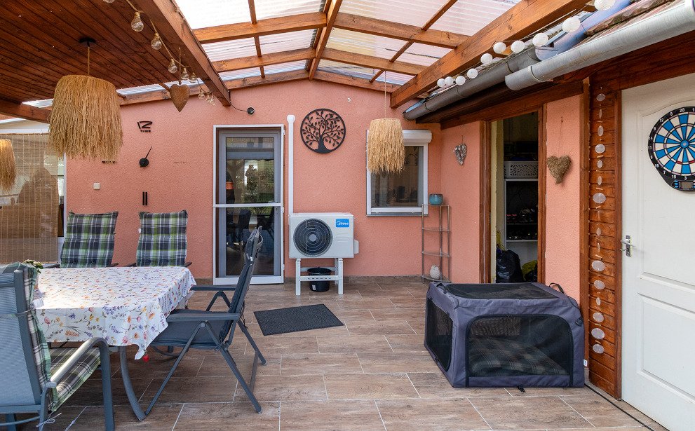 Brightly lit terrace hall with wooden beam ceiling and direct garden access