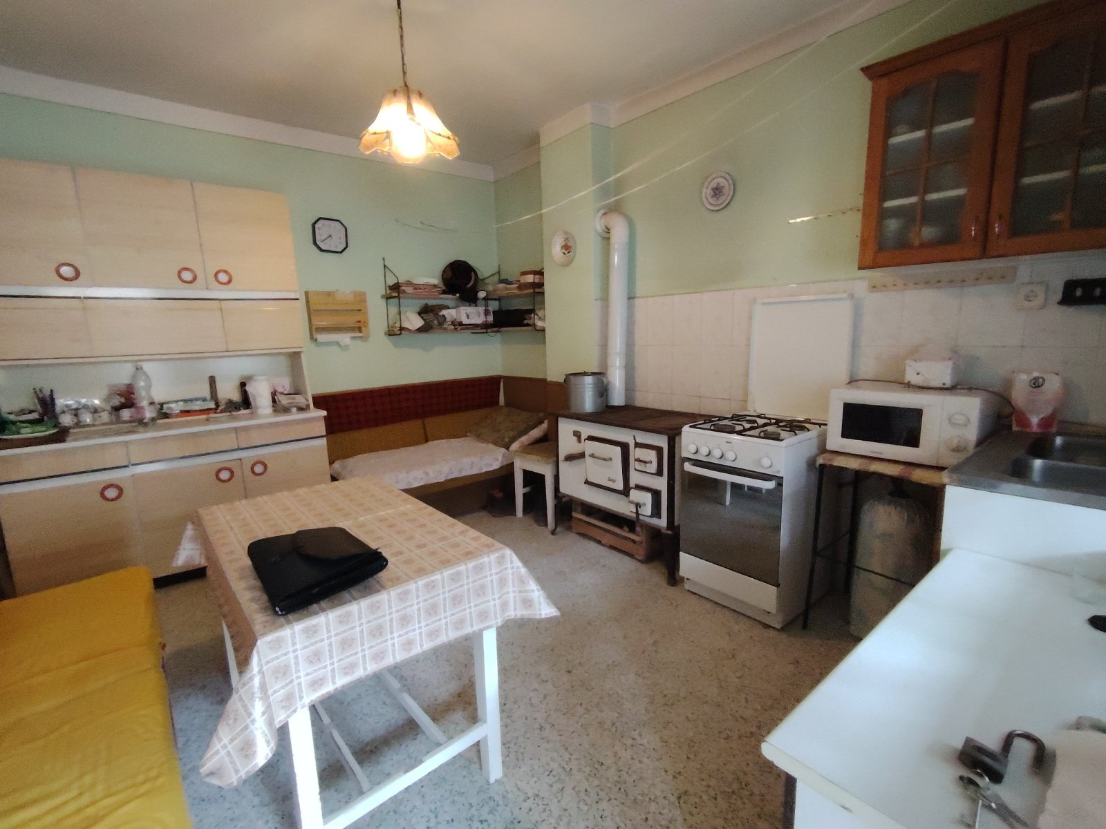 Encantador apartamento en edificio antiguo con carácter: cocina funcional con estufa de madera nostálgica y comodidad de encastre atemporal