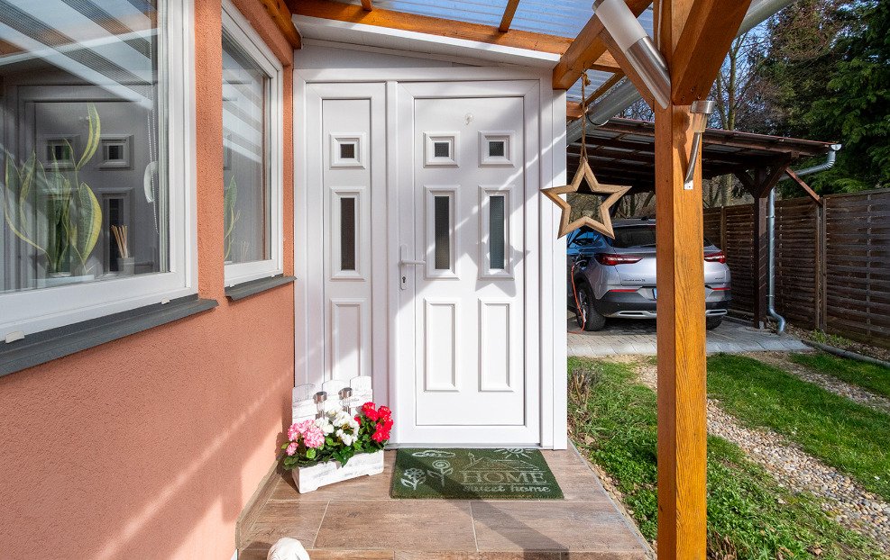 Entrada elegante con puerta de alta calidad y camino cubierto