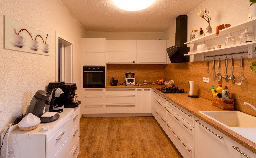 Cocina moderna con equipamiento de alta calidad y organización práctica de las superficies de trabajo