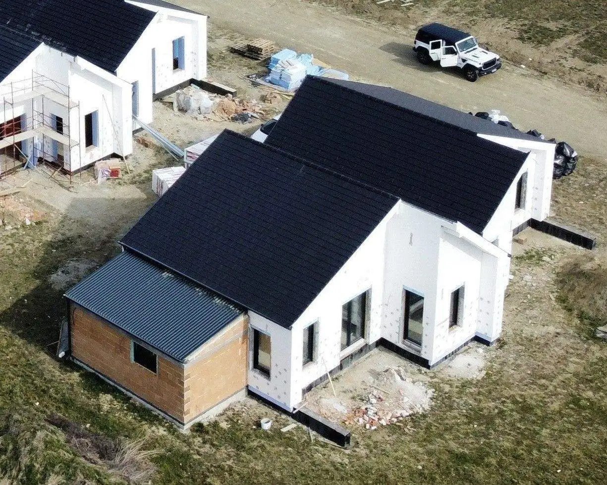 Modern építészeti kiemelkedőség: energiahatékony családi ház intelligens épületkapcsolattal és harmonikus tető kialakítással