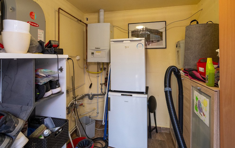 Technische wasruimte met moderne verwarmingsinstallatie en praktische opslagruimte