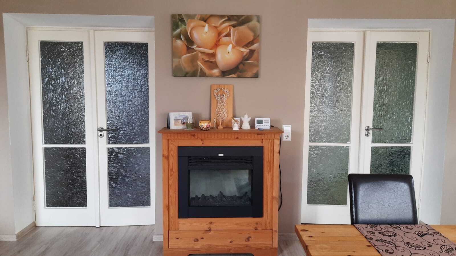 Woonkamer met directe toegang tot terrassen en ingebouwde haard.